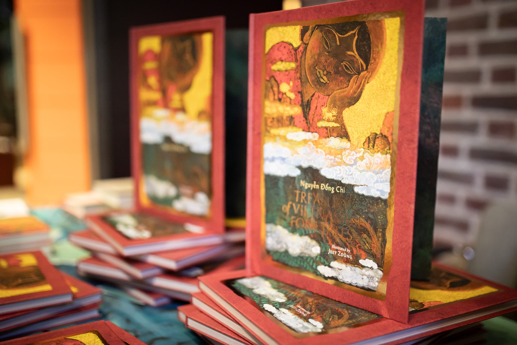 Stack of Treasury books with colorful covers on a table against a brick wall.